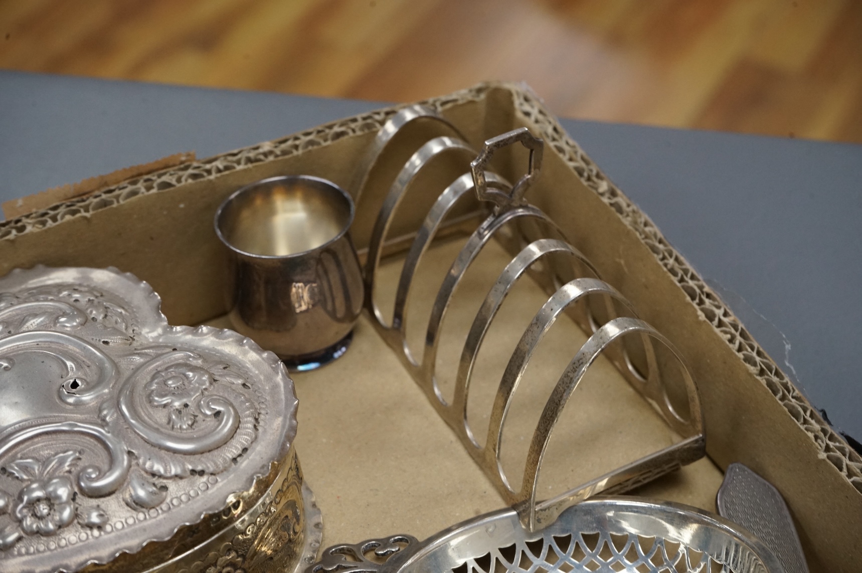 A group of small collectable silver including a late Victorian heart shaped trinket box, Chester, 1899, length 92mm (a.f.), a coaster, toast rack, spill vase, small trinket box, a pair of two handled dishes, napkin ring,